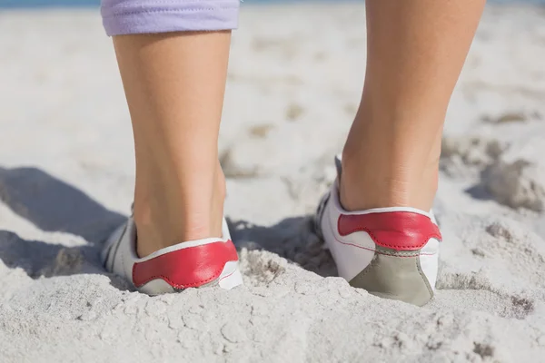 在沙滩上的运动型女人脚 — 图库照片