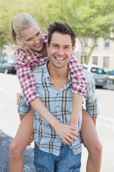 Hombre dando a su novia un cerdito espalda — Foto de Stock