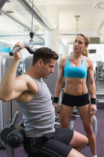 Bodybuilder using weight machine — Stock Photo, Image