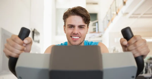 Sorrindo homem apto na bicicleta de exercício — Fotografia de Stock