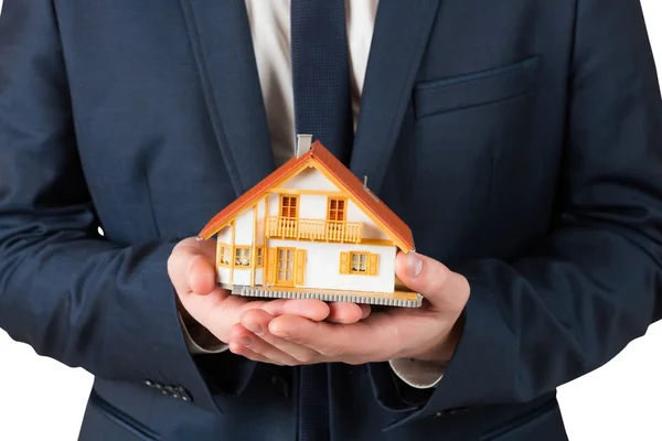 Businessman holding miniature house model — Stock Photo, Image