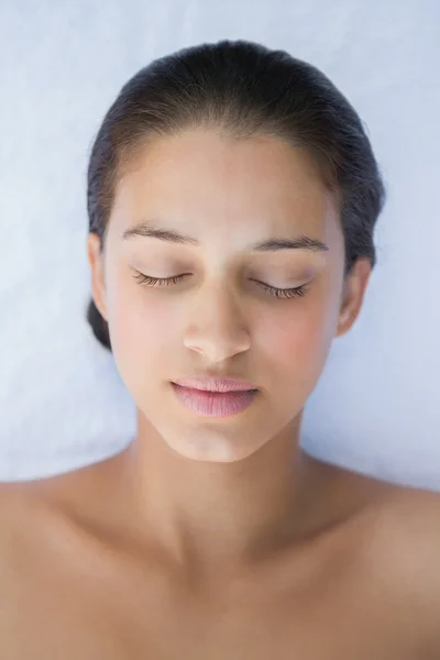 Brunette lying with eyes closed on a towel — Stock Photo, Image