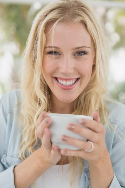 Blonde sitting at table having coffee — Stock Photo, Image