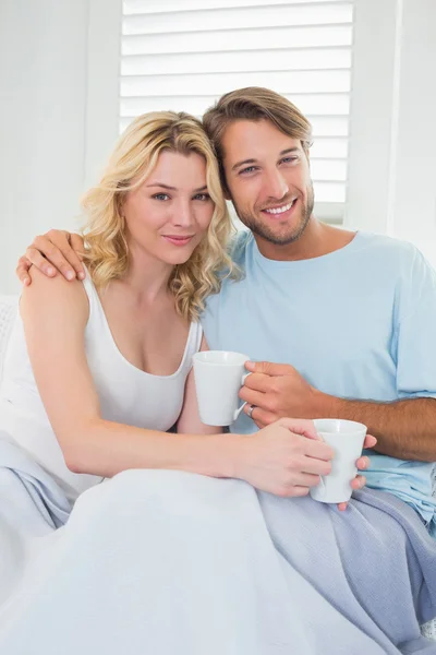 Para na kanapie filiżankę kawy — Zdjęcie stockowe