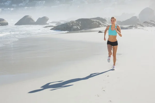 Adatto donna che fa jogging sulla spiaggia — Foto Stock