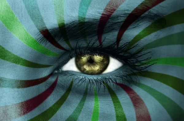 Green eye on patterned face — Stock Photo, Image