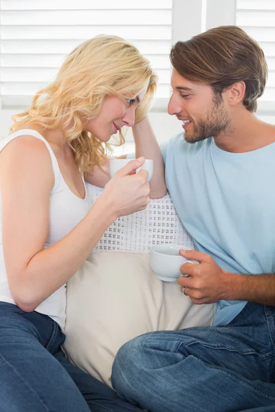 Couple on couch having coffee — Stock Photo, Image