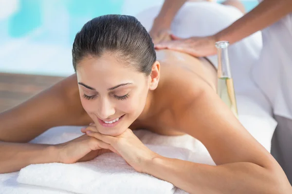 Morena disfrutando de un masaje junto a la piscina — Foto de Stock