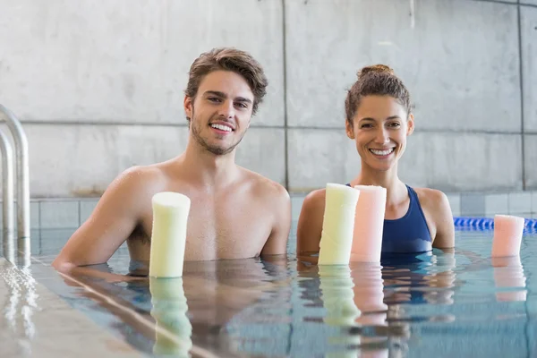 Hombre y mujer con rodillos en la piscina — Foto de Stock