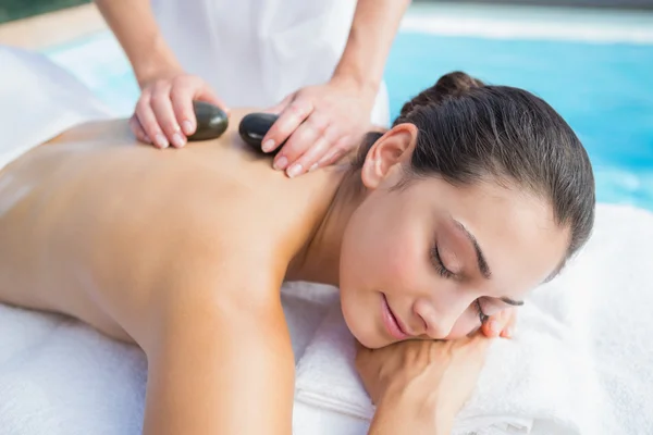 Morena recebendo uma massagem de pedra quente — Fotografia de Stock