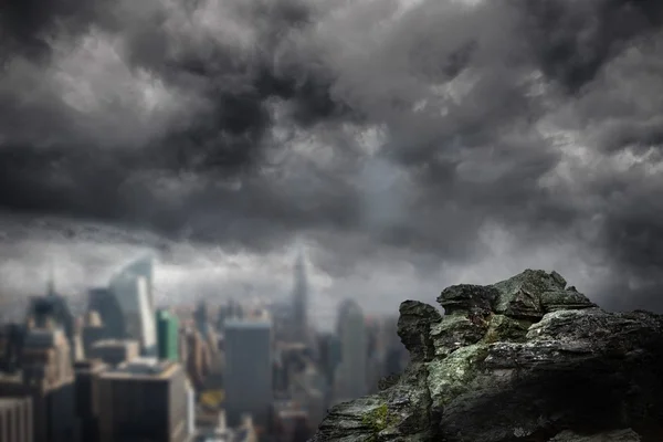 Rock overlooking dark city — Stock Photo, Image