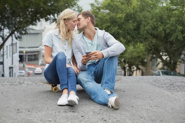 Hip pareja sentado en skateboard besos — Foto de Stock