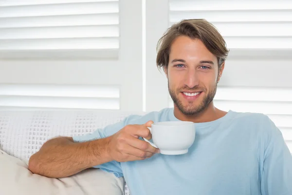 Hombre en el sofá tomando café — Foto de Stock