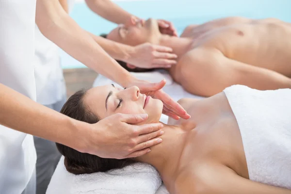 Couple enjoying couples massage poolside — Stock Photo, Image