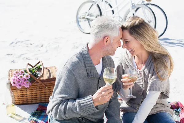 Casal desfrutando de vinho em piquenique na praia — Fotografia de Stock
