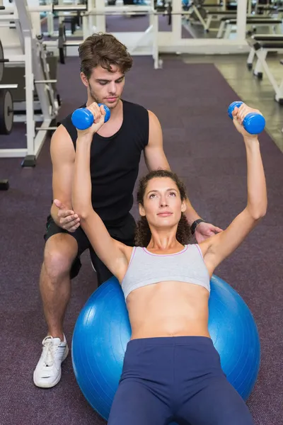 Entraîneur et client allongé sur le ballon d'exercice — Photo