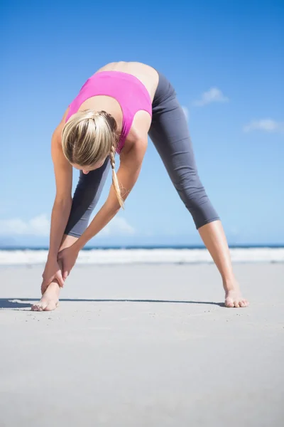 Blonde warming-up op het strand — Stockfoto