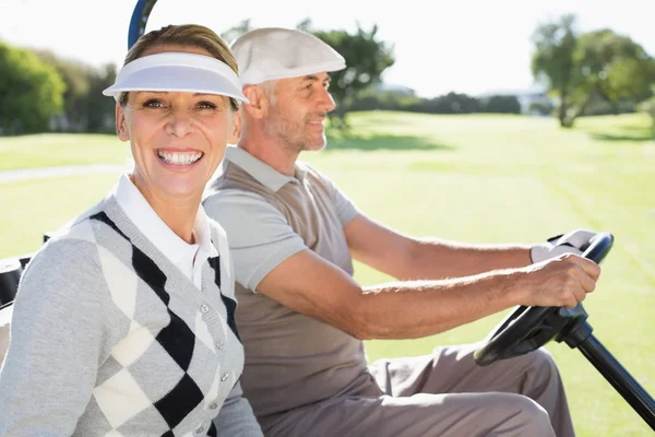 Feliz casal de golfe dirigindo em seu buggy — Fotografia de Stock