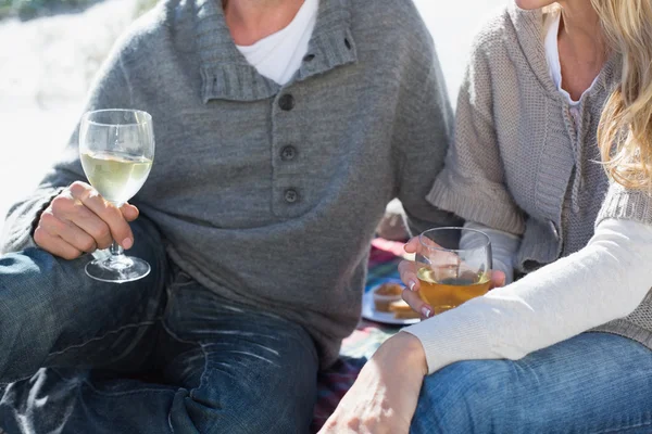 Casal desfrutando de vinho em piquenique na praia — Fotografia de Stock