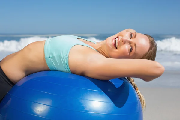 Vrouw liggend op oefening ball op strand — Stok fotoğraf