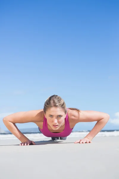 Blonde en position de planche sur la plage — Photo