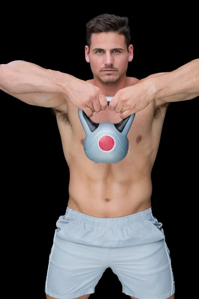 Focused bodybuilder swinging up kettlebell — Stock Photo, Image