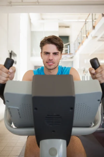 Homme de forme concentré sur le vélo d'appartement — Photo