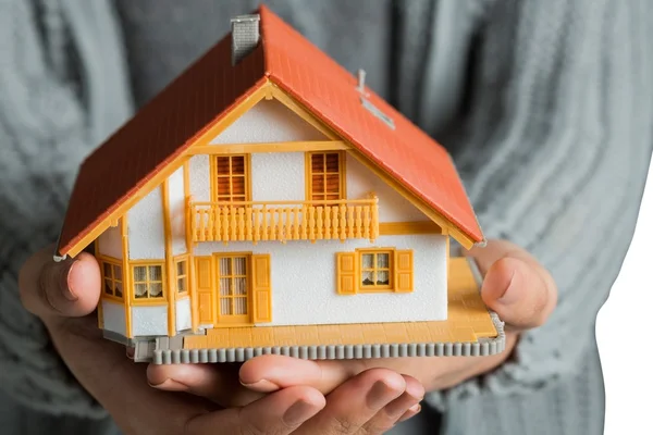 Handen tonen een miniatuur model huis — Stockfoto