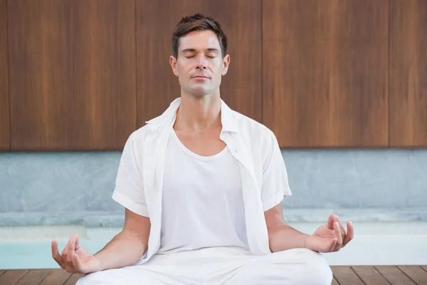 Man in white meditating in lotus pose — Stock Photo, Image