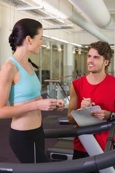 Trainer talking to his client on the treadmill — Stock Photo, Image