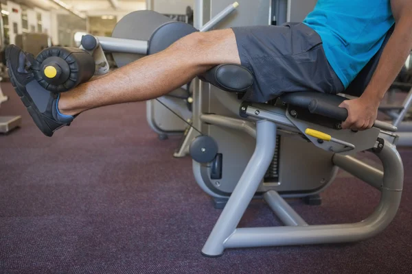 Hombre usando la máquina de pesos para las piernas — Foto de Stock