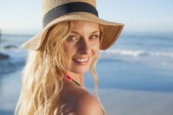 Loira em chapéu de palha sorrindo na praia — Fotografia de Stock