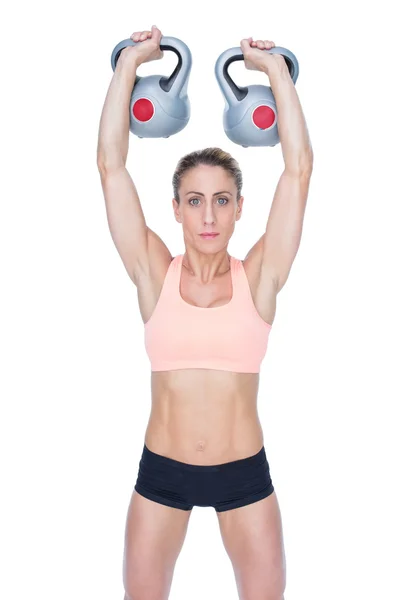 Vrouwelijke crossfitter opheffing kettlebells — Stockfoto