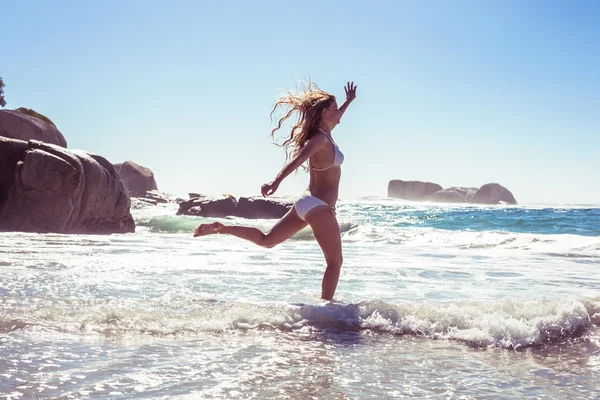 Frau im Bikini hüpft am Strand — Stockfoto