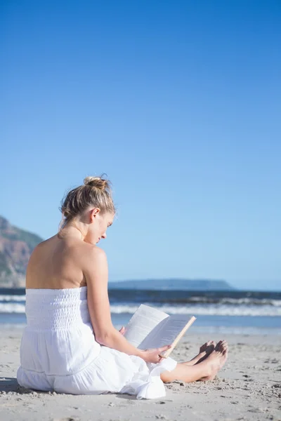 Bionda seduta sulla spiaggia lettura libro — Foto Stock