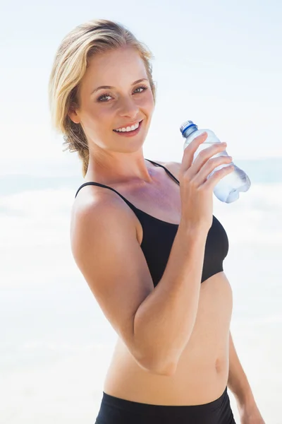 Blonde drinking water on beach — Stock Photo, Image
