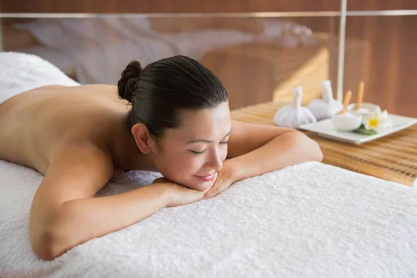 Brunette relaxante na mesa de massagem — Fotografia de Stock