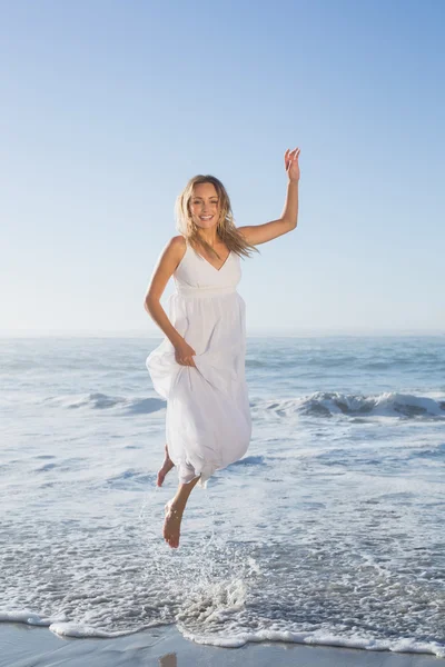 Blonde springen op strand — Stockfoto