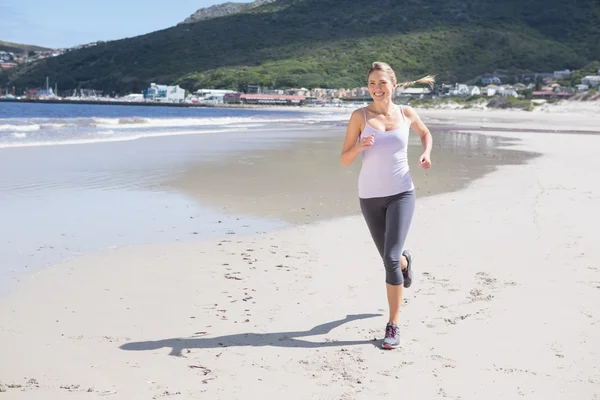 Blonde joggen op het strand — Stockfoto