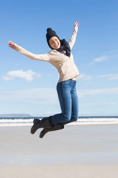 Loira de jeans pulando na praia — Fotografia de Stock
