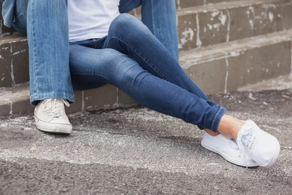 Hip couple in denim sitting on steps — Stock Photo, Image