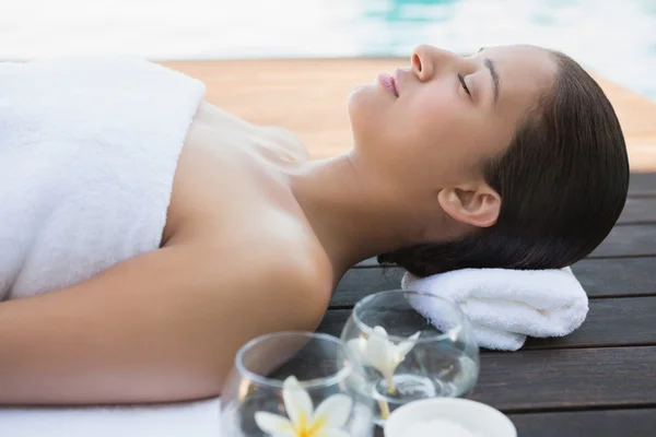 Brunette lying with eyes closed on a towel — Stock Photo, Image