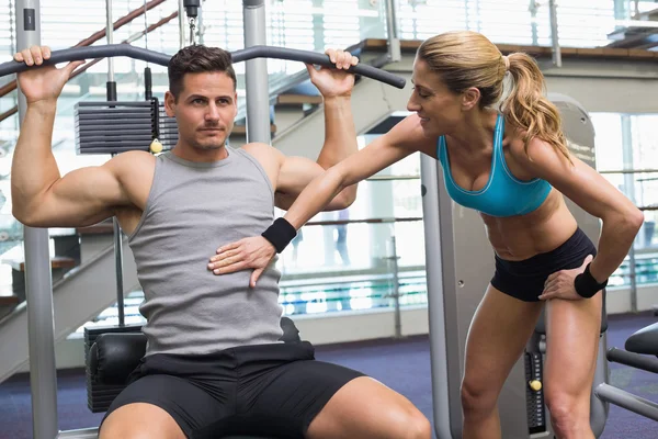 Bodybuilder using weight machine for arms — Stock Photo, Image