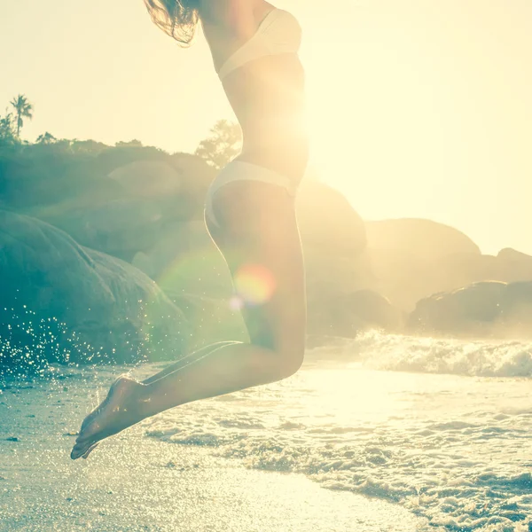 Springen blonde in bikini op het strand — Stockfoto