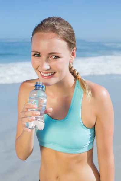 Fit woman on beach taking drink — Stock Photo, Image