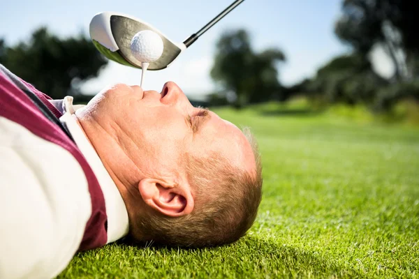 Golfspelare anläggning tee i hans tänder — Stockfoto