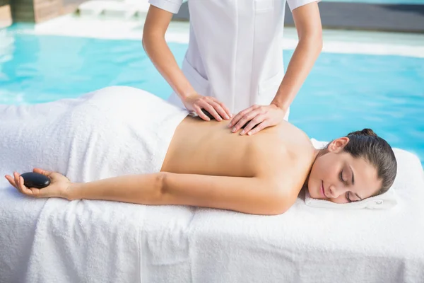 Morena recebendo uma massagem de pedra quente — Fotografia de Stock