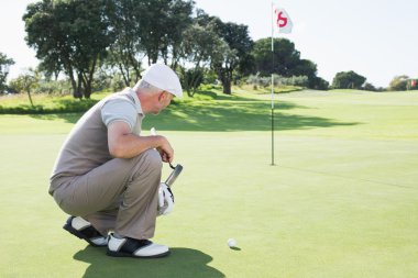 Golfer on putting green at eighteenth hole clipart