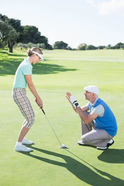 Uomo coaching il suo partner sul putting green — Foto Stock