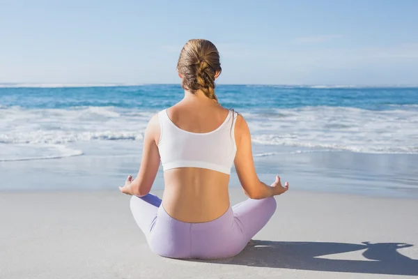 Sporty blonde in lotus pose on beach — Stock Photo, Image